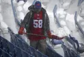Volunteers contribute to cleaning the snow-covered field for a playoff game of the Buffalo Bills team